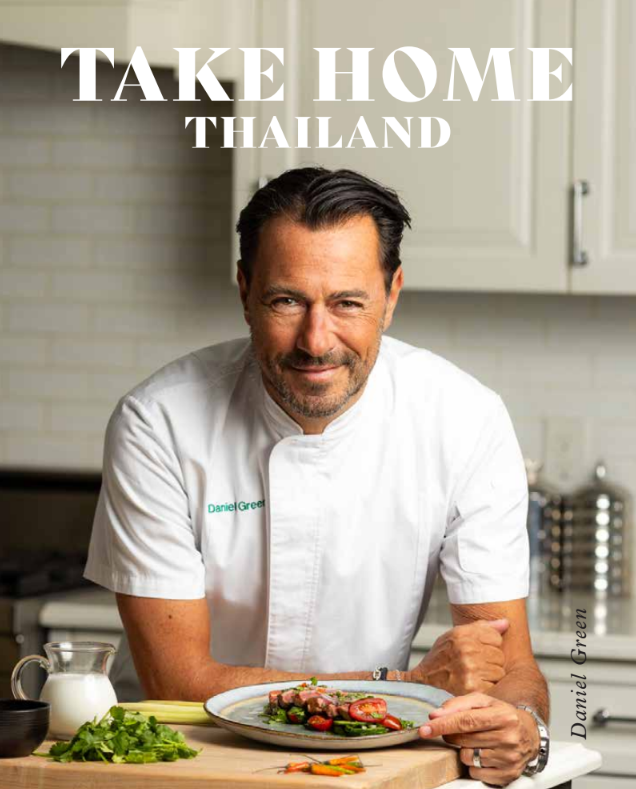 Chef posing with a plated dish in a kitchen setting.